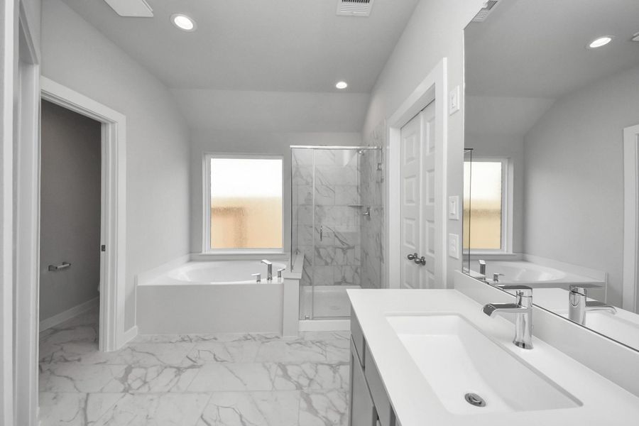 Escape to a spa-like oasis in this primary bathroom. Enjoy a walk-in shower with tile surround, a separate garden tub with custom detailing, and an elegant vanity featuring light countertops, modern hardware, and beautiful recessed lights. Experience luxury and relaxation in every detail. Escape to a spa-like oasis in this primary bathroom. Enjoy a walk-in shower with tile surround, a separate garden tub with custom detailing, and an elegant vanity featuring light countertops, modern hardware, and beautiful recessed lights. Experience luxury and relaxation in every detail.