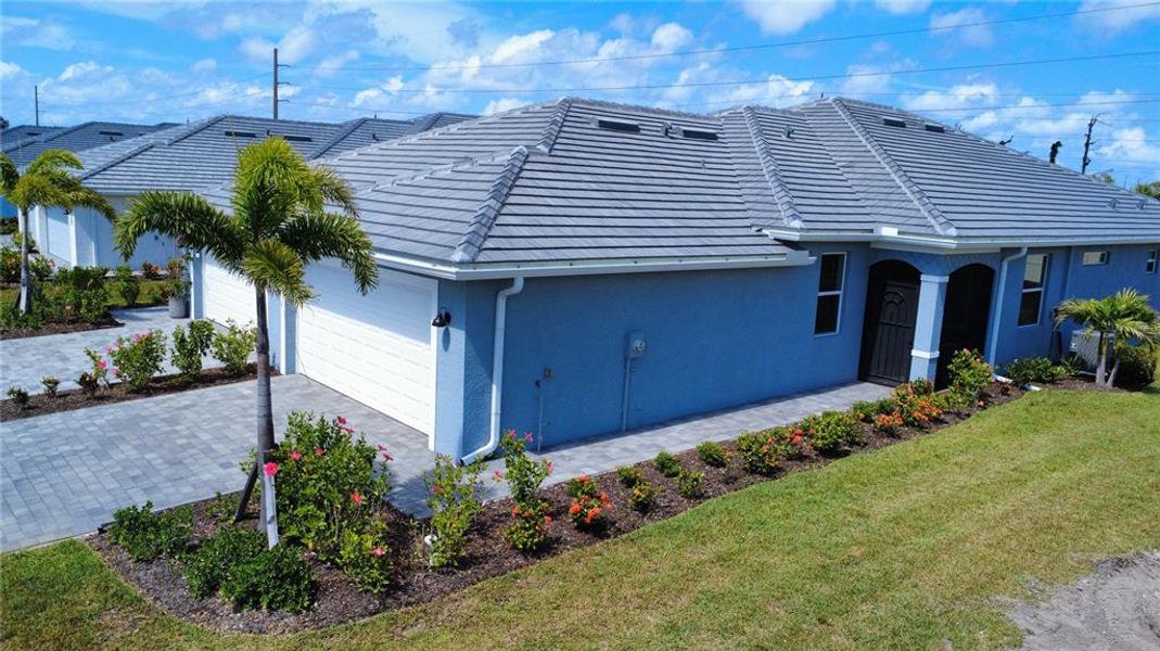 Front exterior of a new home in Palm Lake at Coco Bay, Englewood, FL, highlighting curb appeal (Image 2). Front exterior of a new home in Palm Lake at Coco Bay, Englewood, FL, highlighting curb appeal (Image 2).