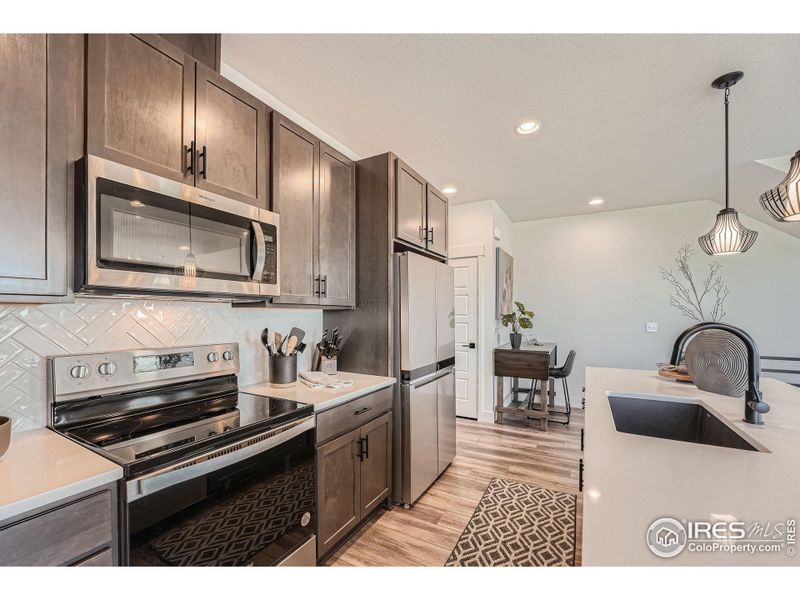 Modern, stainless-steel appliances grace the kitchen.