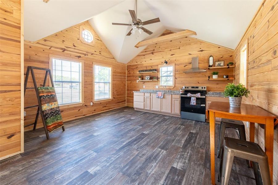 Vaulted ceiling with exposed wood beams and a ceiling fan