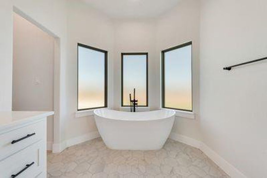 Bathroom featuring vanity, tile patterned flooring, and a bathing tub