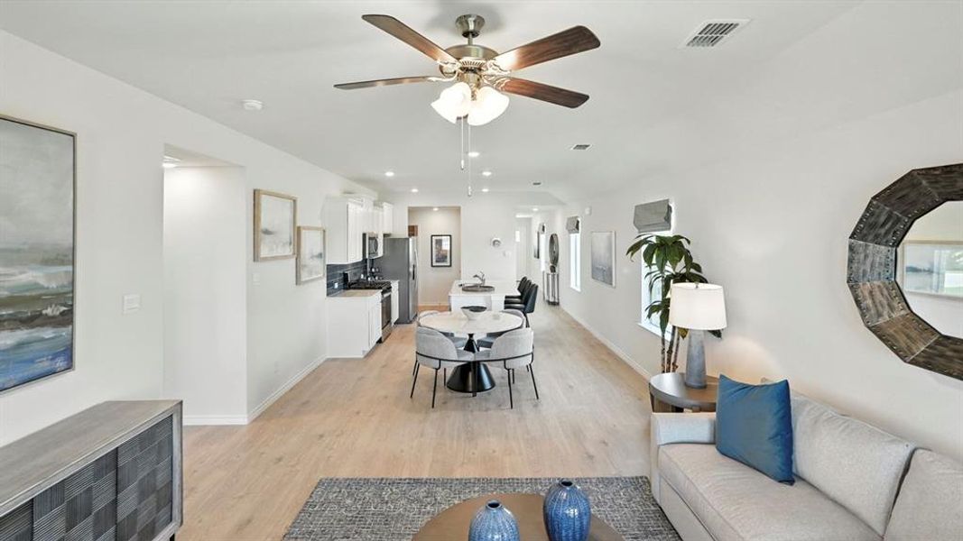 Living area featuring light wood-style floors, a ceiling fan, and recessed lighting