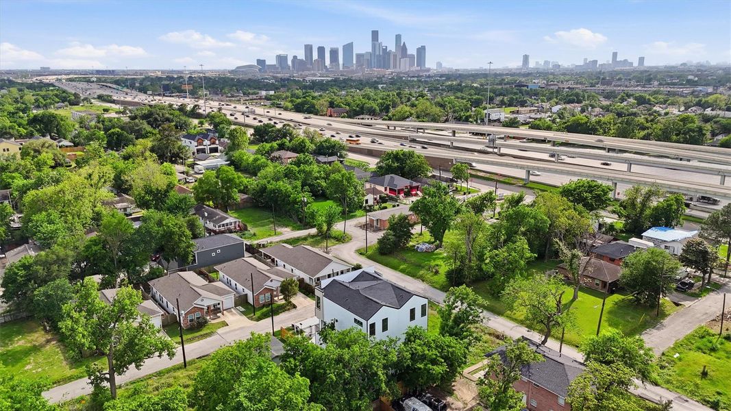 Panoramic aerial view highlighting the property’s proximity to Downtown Houston, with clear skyline views, nearby highway access, and surrounding tree-lined neighborhoods showcasing an ideal urban location.