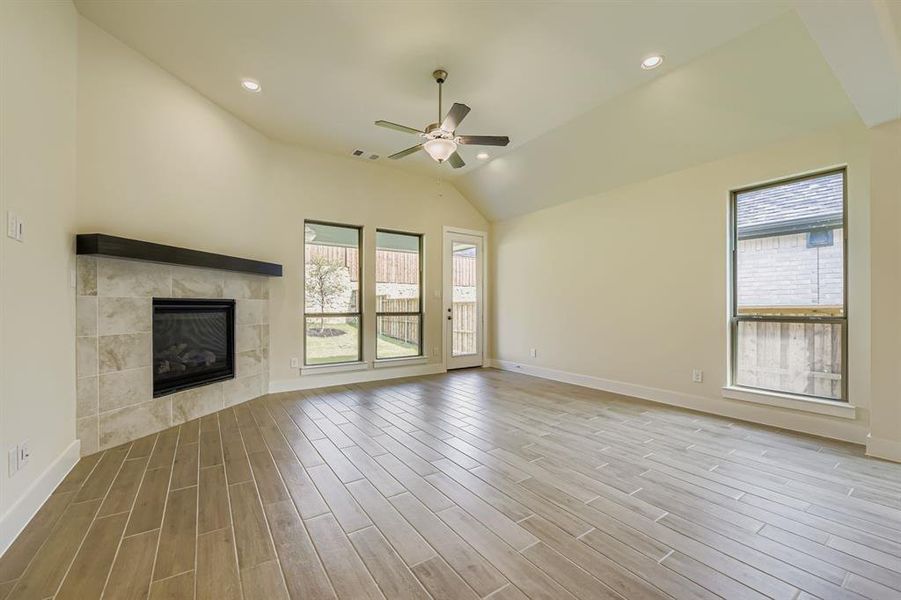 Unfurnished living room featuring recessed lighting, a fireplace, ceiling fan, light wood-type flooring, and lofted ceiling