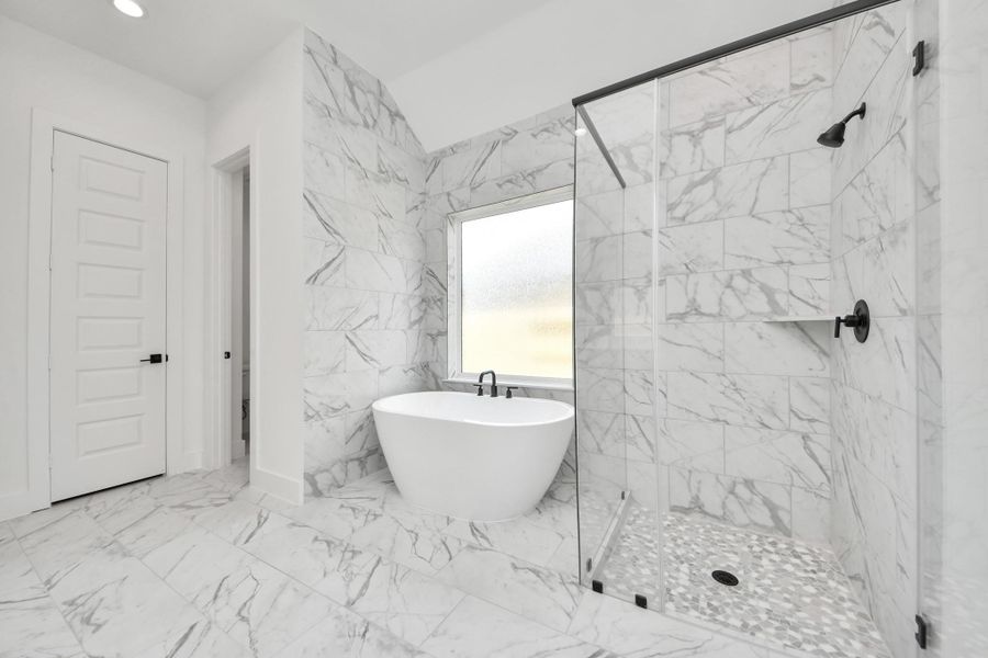 Indulge in a spa-like retreat within the confines of this primary bathroom. Delight in a spacious walk-in shower enveloped in stylish tile surround, unwind in a separate garden tub adorned with custom detailing. Indulge in a spa-like retreat within the confines of this primary bathroom. Delight in a spacious walk-in shower enveloped in stylish tile surround, unwind in a separate garden tub adorned with custom detailing.