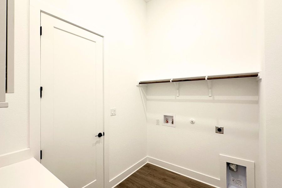 A dedicated utility space, this laundry room features ample room for appliances and a convenient hanging rod.