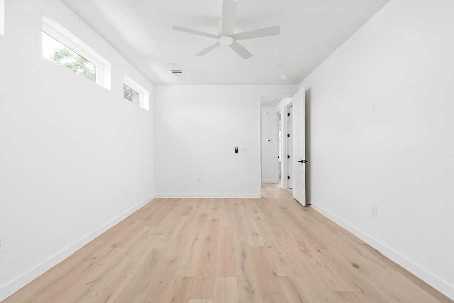 Unfurnished room with light wood finished floors and ceiling fan Unfurnished room with light wood finished floors and ceiling fan