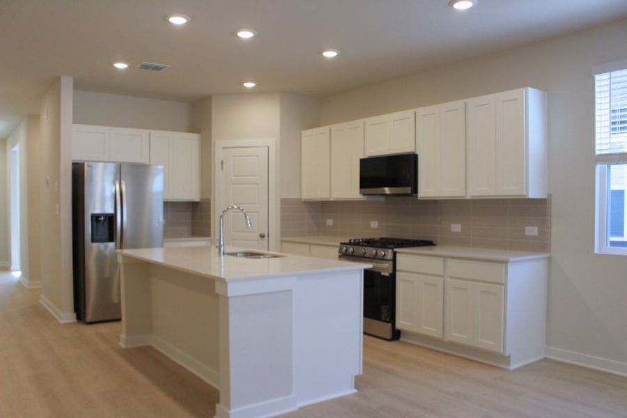 A kitchen with white cabinets.