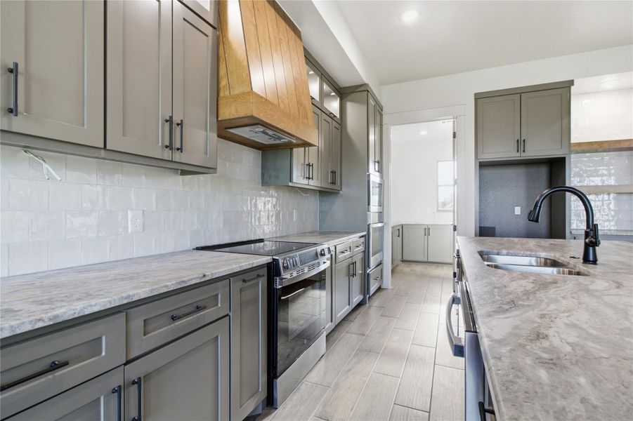 Culinary aspirations come to life in this modern kitchen featuring a sleek range and stylish stone counters. Culinary aspirations come to life in this modern kitchen featuring a sleek range and stylish stone counters.