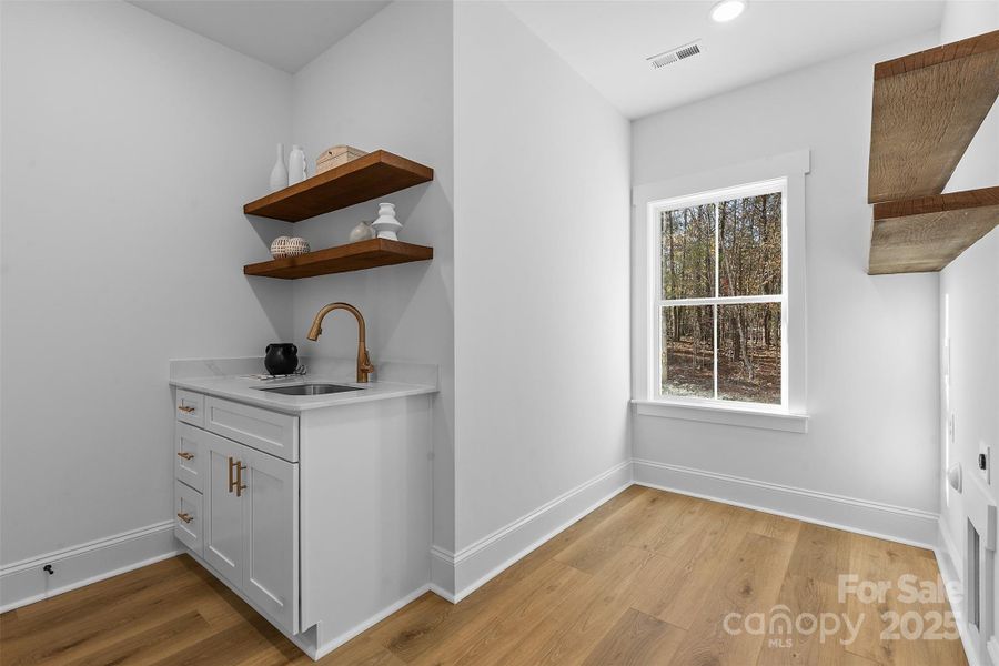 *representative photo- laundry room/mud room w/ extra storage, laundry sink, and wood shelving