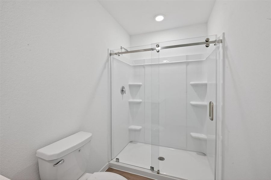 The ensuite bath in the primary features a large walk-in shower.