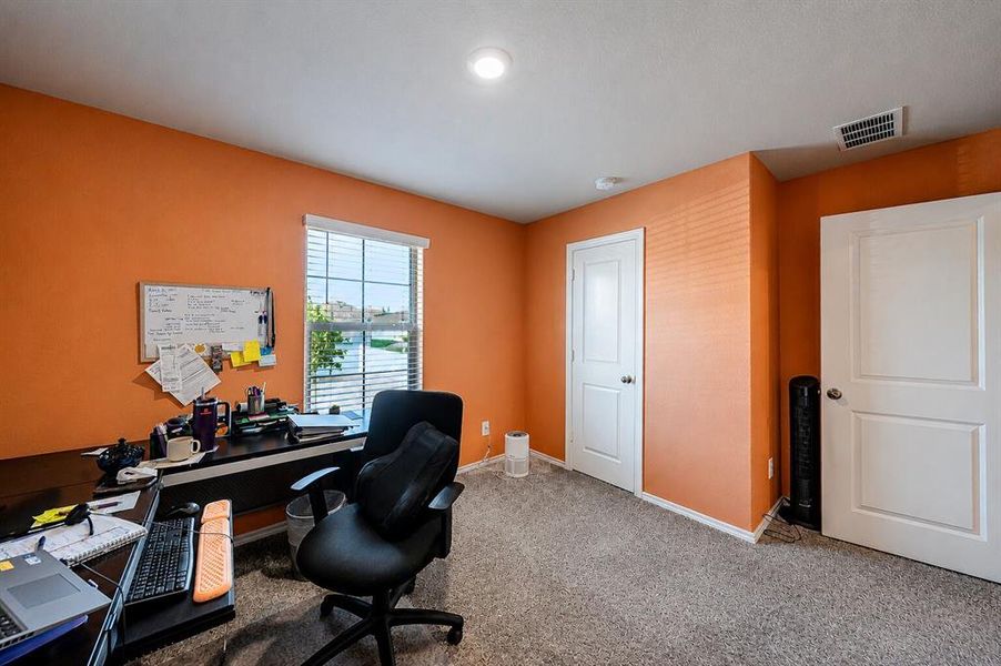 Room with orange walls, grey carpeting, a window with blinds, and white doors