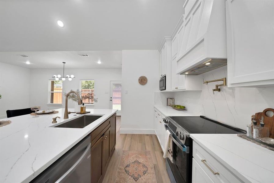 Modern kitchen featuring a large island with an undermount sink and a brushed nickel faucet Modern kitchen featuring a large island with an undermount sink and a brushed nickel faucet