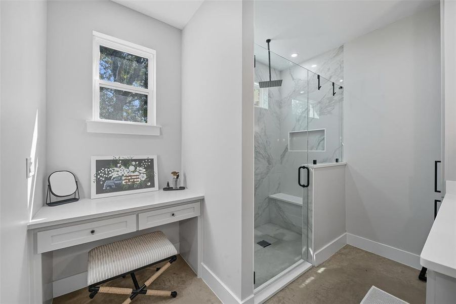 Bathroom featuring a marble finish shower and concrete floors Bathroom featuring a marble finish shower and concrete floors