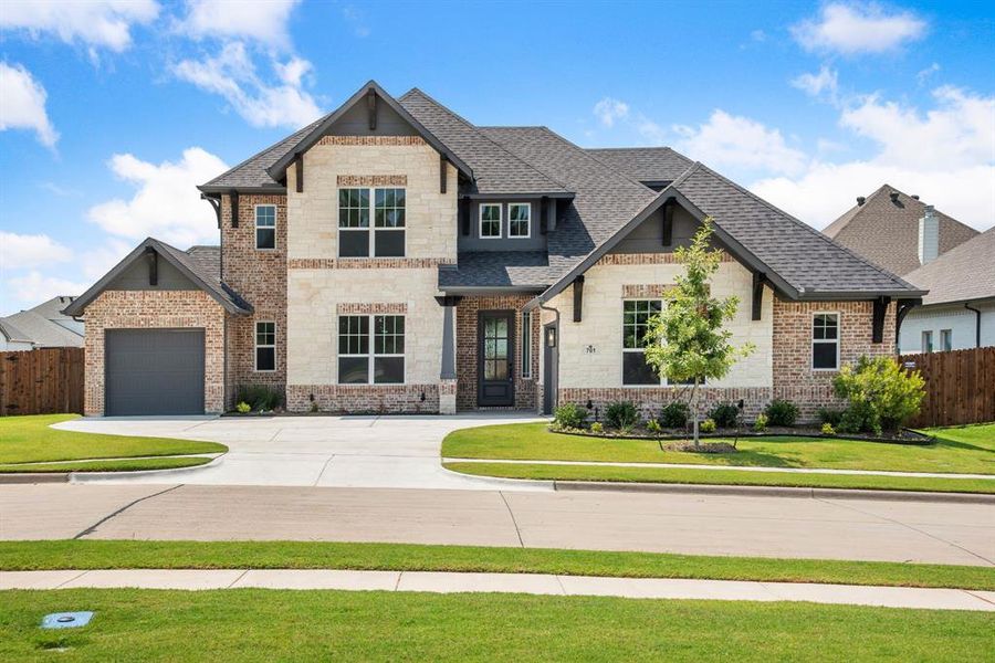 View of front of property with a garage and a front yard