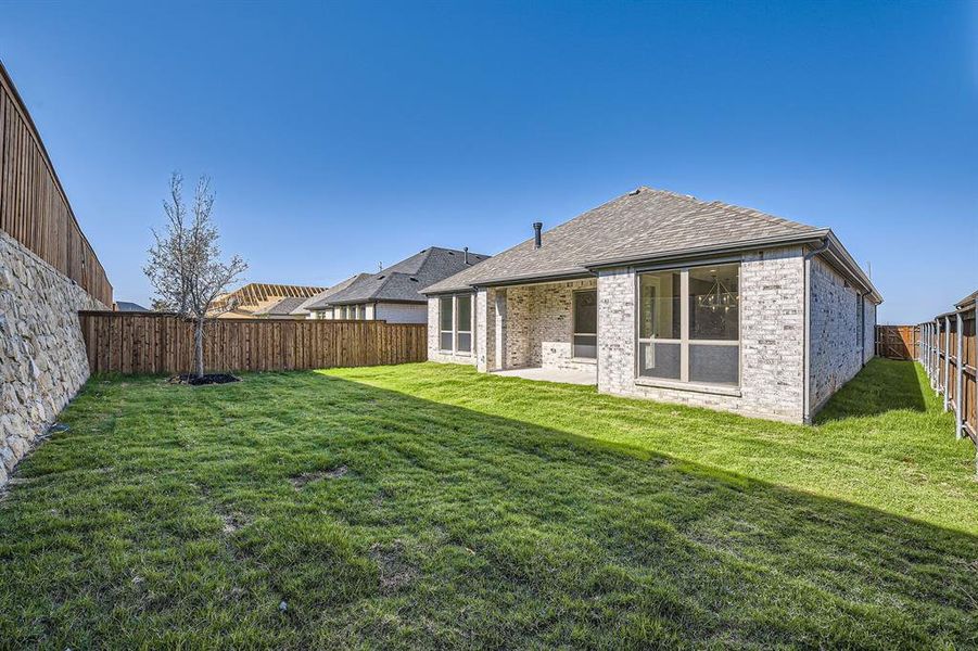 Rear view of house with a patio area and a lawn