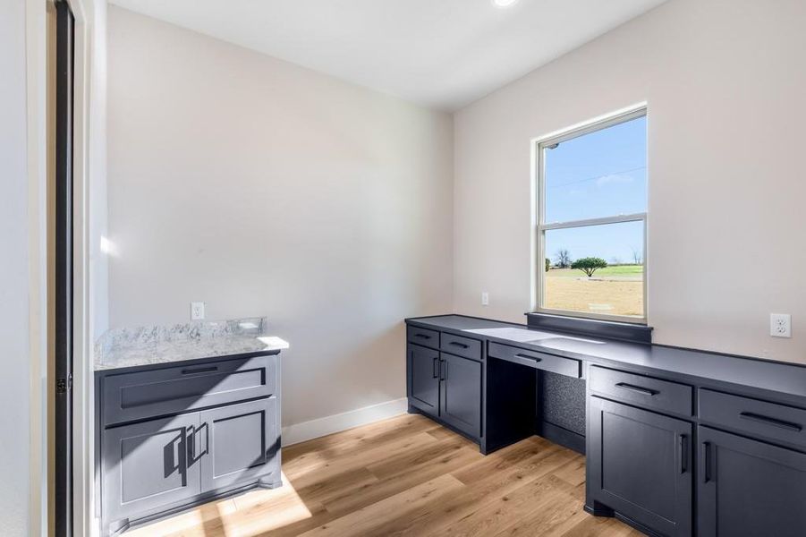 Kitchen featuring built in desk and light hardwood / wood-style flooring