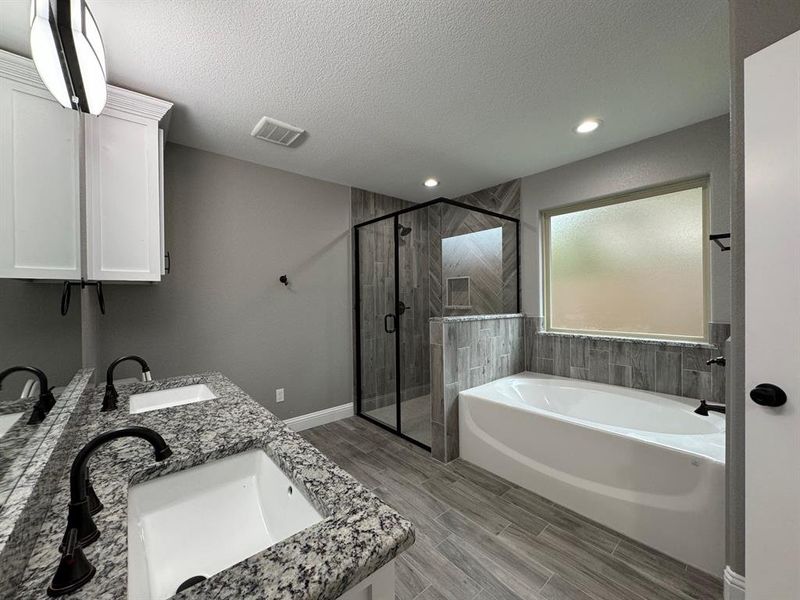 Bathroom with plus walk in shower, vanity, a textured ceiling, and hardwood / wood-style flooring