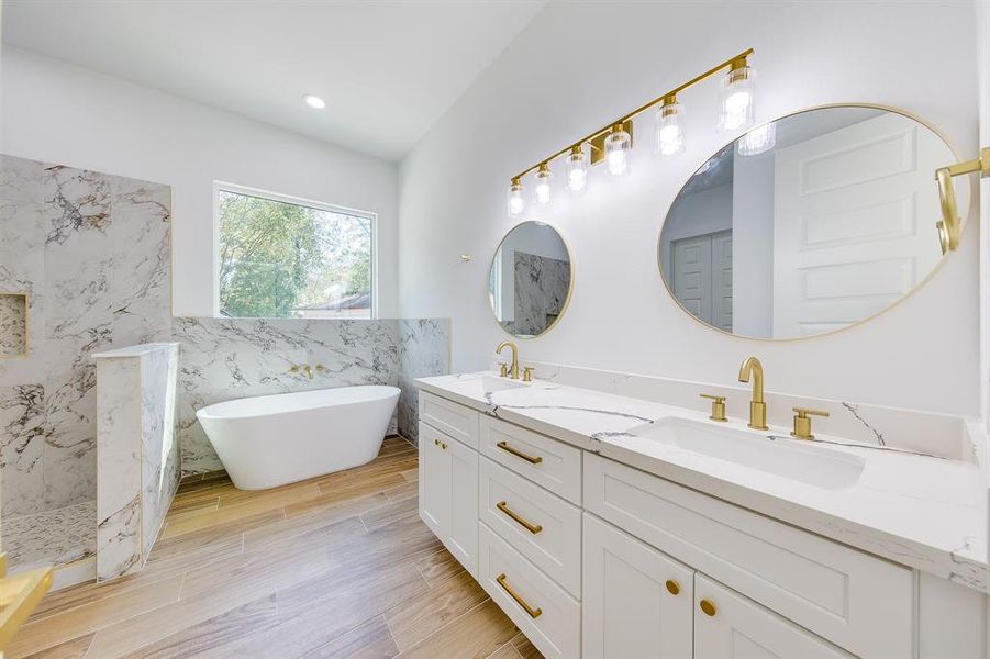 Treat yourself to a spa-like experience in the luxurious bathroom featuring a jetted tub and separate shower. Indulge in a relaxing soak or refresh under the rainfall showerhead—this space is designed for ultimate comfort and relaxation.