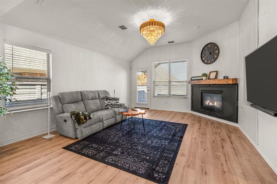 Living room with light hardwood / wood-style floors and lofted ceiling