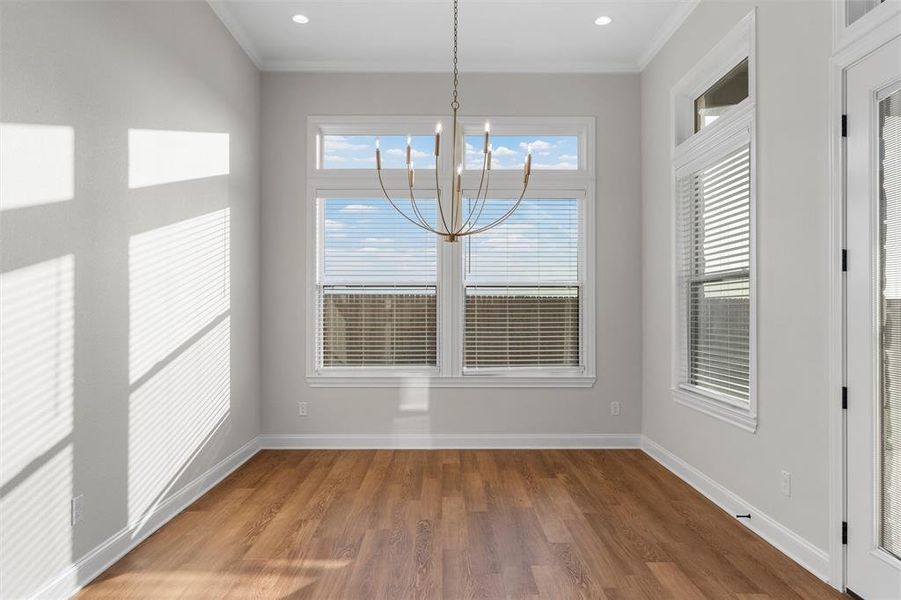 Unfurnished dining area featuring light wood finished floors, a chandelier, crown molding, and recessed lighting Unfurnished dining area featuring light wood finished floors, a chandelier, crown molding, and recessed lighting