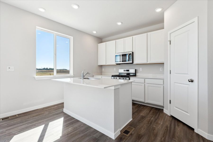 A kitchen with white cabinets.
