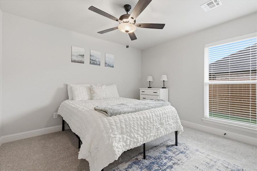 Bright bedroom featuring a large window that fills the space with natural light and creates an inviting atmosphere.