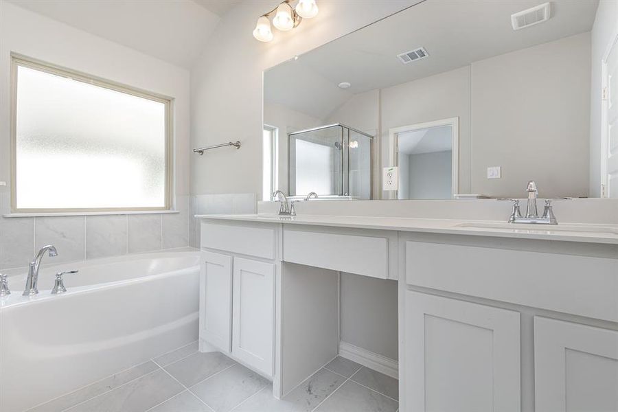 Bathroom with vanity, plus walk in shower, and vaulted ceiling