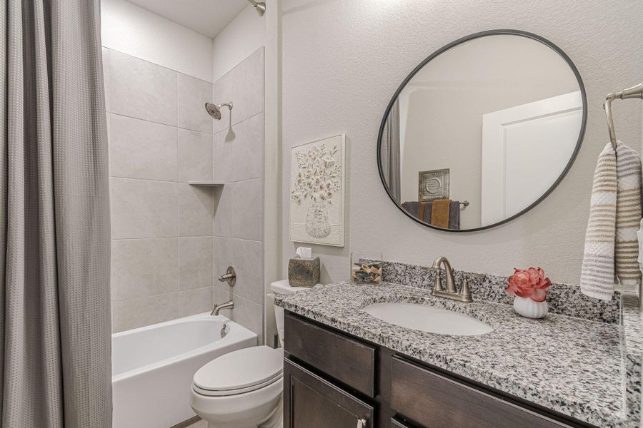 Bathroom featuring shower / tub combo, toilet, and vanity
