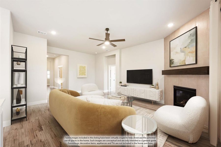 Living room with tile fireplace, ceiling fan, hardwood floors, and neutral seating area Living room with tile fireplace, ceiling fan, hardwood floors, and neutral seating area