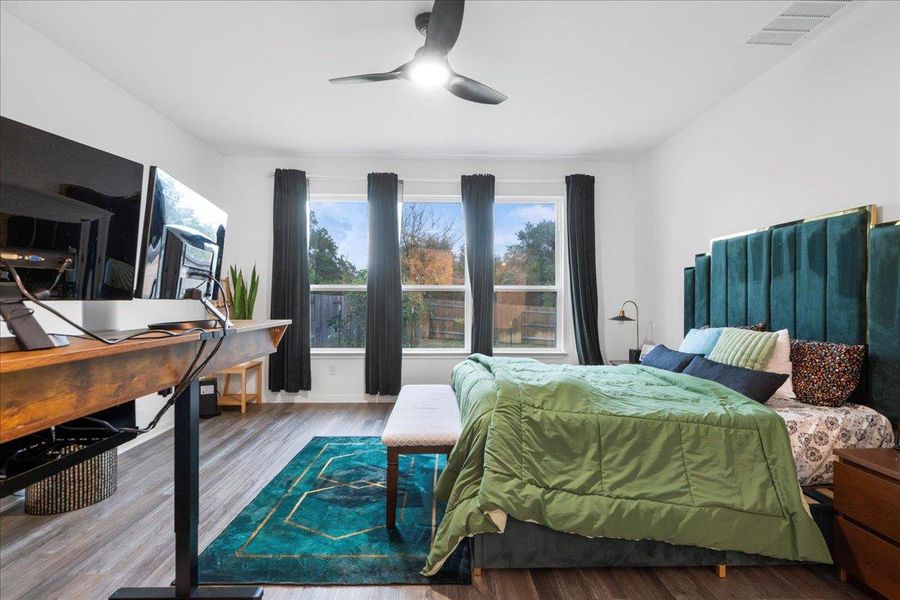 Bedroom featuring an office area, wood finished floors, and a ceiling fan