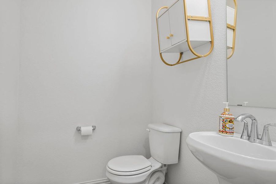 Bathroom featuring toilet and a sink Bathroom featuring toilet and a sink