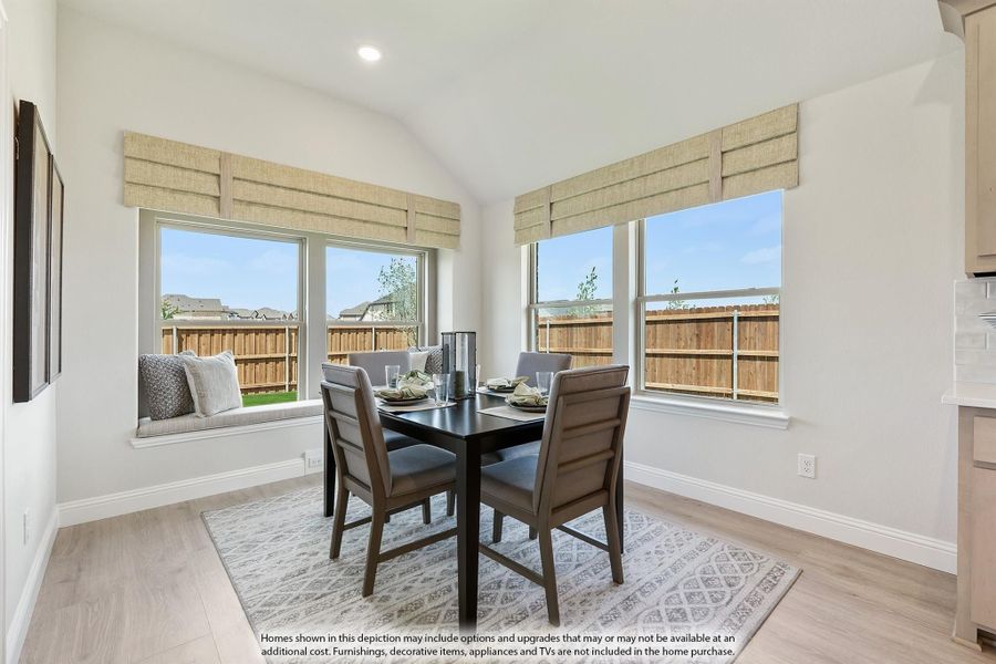 Dining area with dark wood table, four chairs, window seat, and large windows with vaulted ceiling