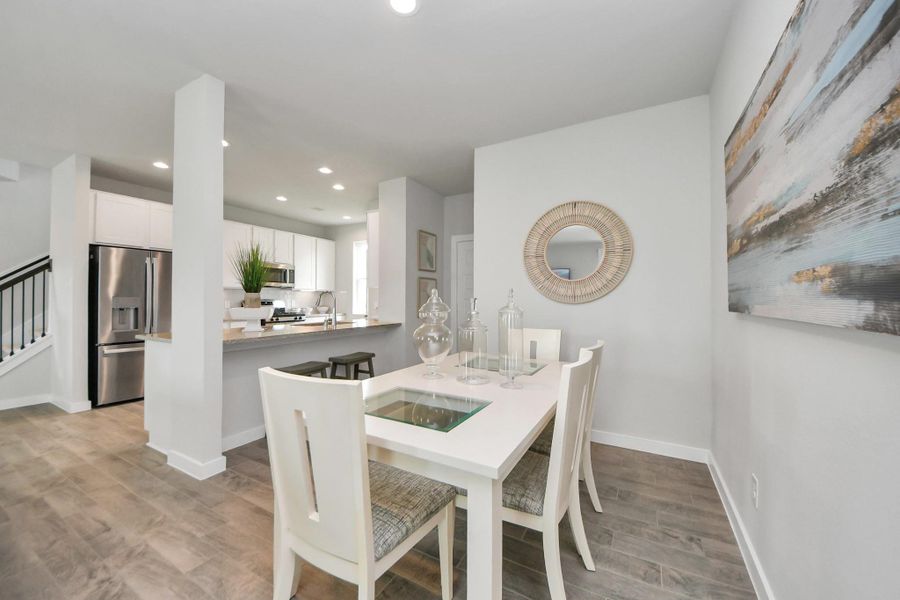Make memories gathered around the table with your family and friends! This spacious dining room features elegant flooring, custom paint, and adjacent to family room and kitchen for open concept feel. Sample photo of completed home with similar floor plan. Actual colors and selections may vary.