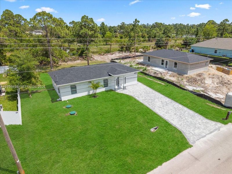 Contemporary residence with a dark shingle roof, white exterior siding, and a paver driveway Contemporary residence with a dark shingle roof, white exterior siding, and a paver driveway