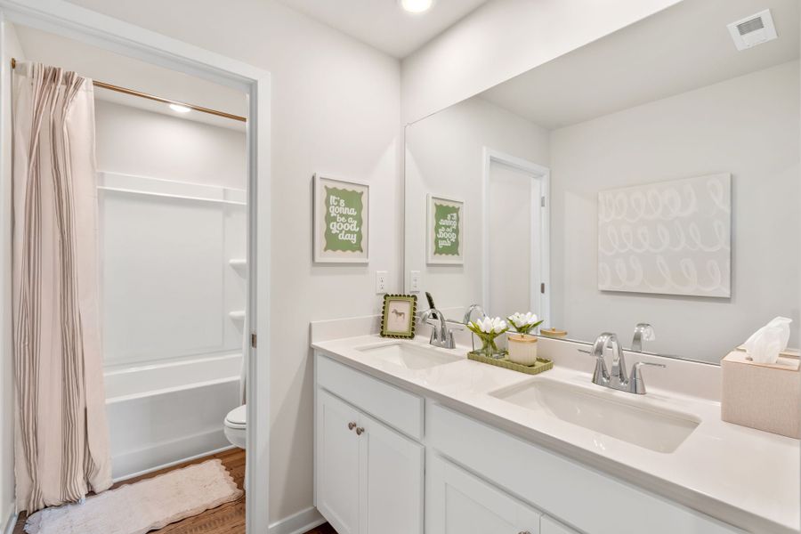 A bathroom with a tub sink and toilet.