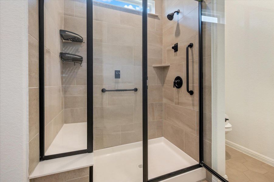 Bathroom featuring a stall shower and toilet Bathroom featuring a stall shower and toilet