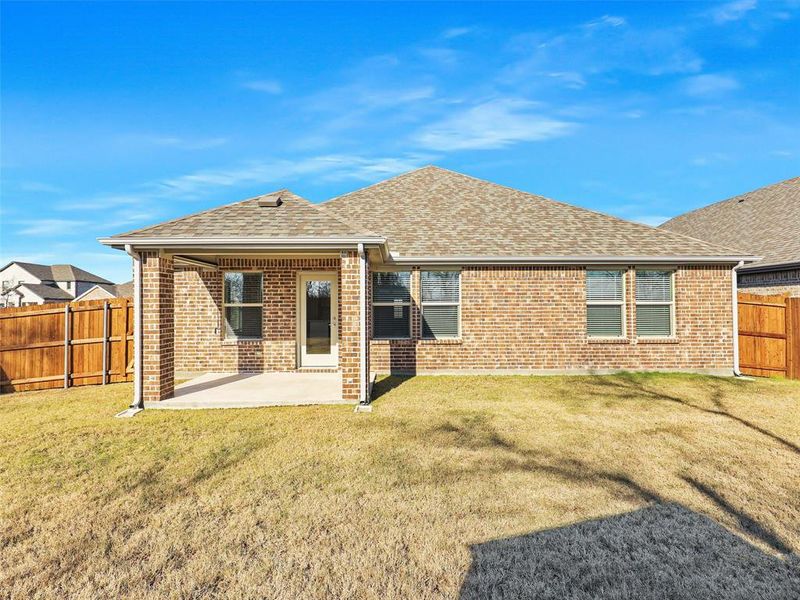 Rear view of house with a lawn and a patio area