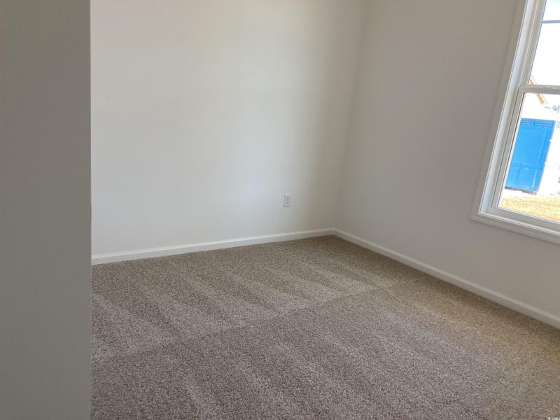 Carpeted spare room with baseboards