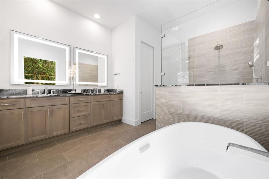 Bathroom featuring a tile shower, double vanity, a freestanding bath, and tile patterned flooring Bathroom featuring a tile shower, double vanity, a freestanding bath, and tile patterned flooring