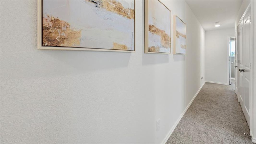 Hallway featuring baseboards and light carpet