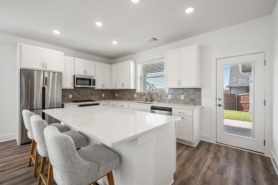 Kitchen features lots of granite counter space, with ceramic backsplash, GE appliances, gas cooktop, oven,  microwave, dishwasher, with Moen faucet, stainless steel undermount sink with garbage disposal.