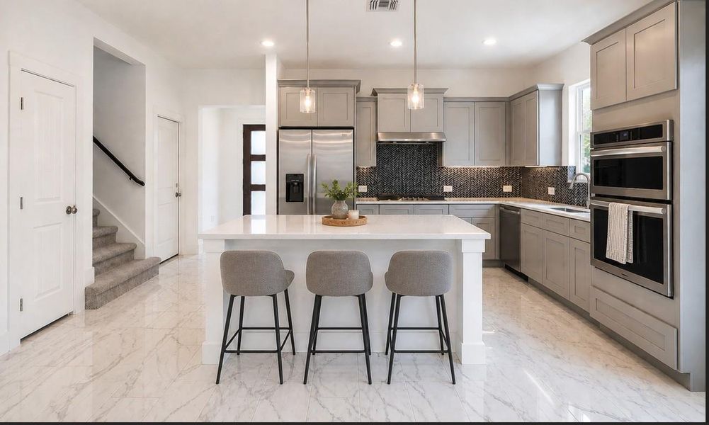 Beautiful kitchen featuring an island, pendant lighting and stainless steel appliances Beautiful kitchen featuring an island, pendant lighting and stainless steel appliances