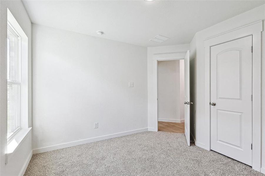 Unfurnished bedroom with light colored carpet