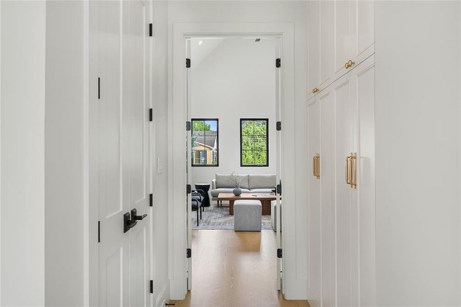 Hallway featuring wood-finish flooring and integrated cabinetry with gold-tone hardware