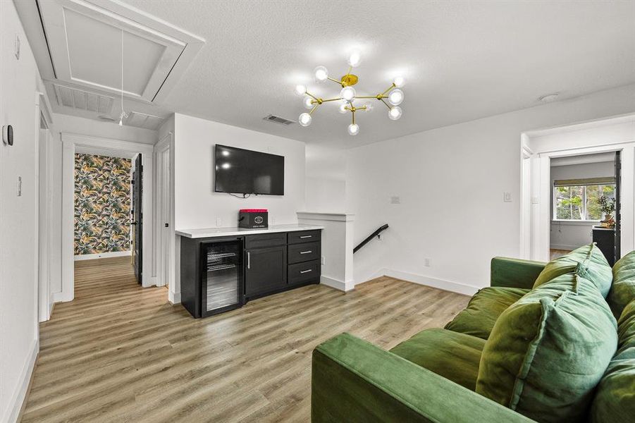 Gameroom with built in dry bar and beverage cooler and quartz counters.