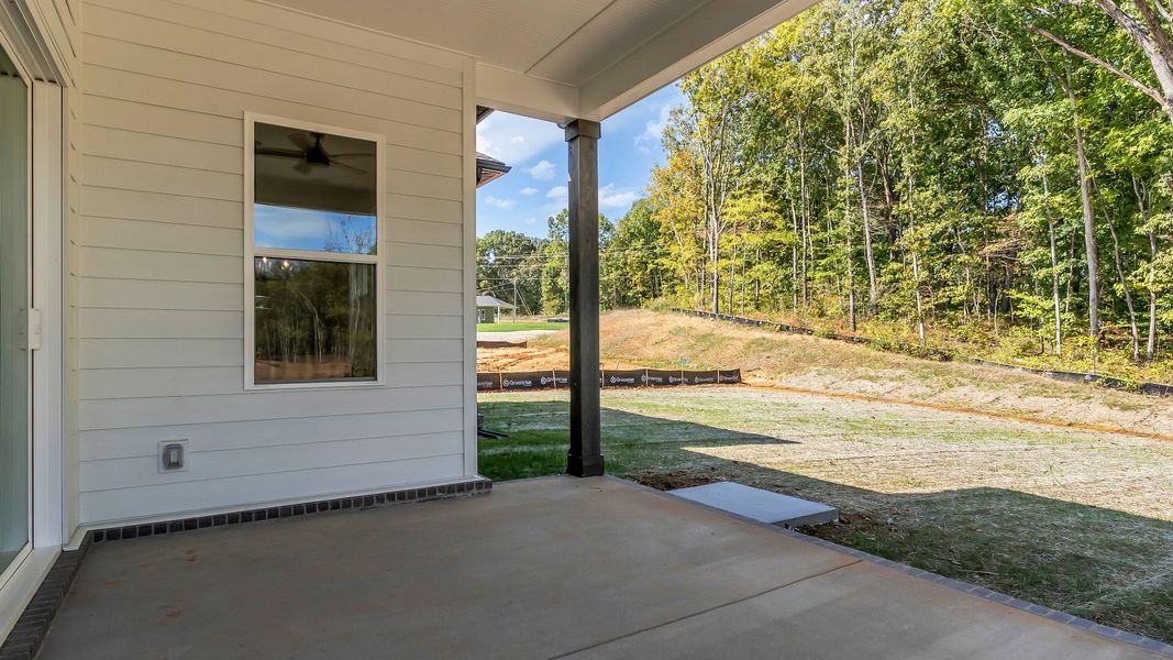 Exterior of home with covered rear porch (Representative of finished home)