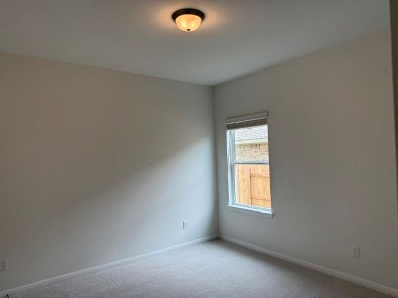 Neutral-toned room featuring a single window with a blind, light-colored walls, and carpet flooring