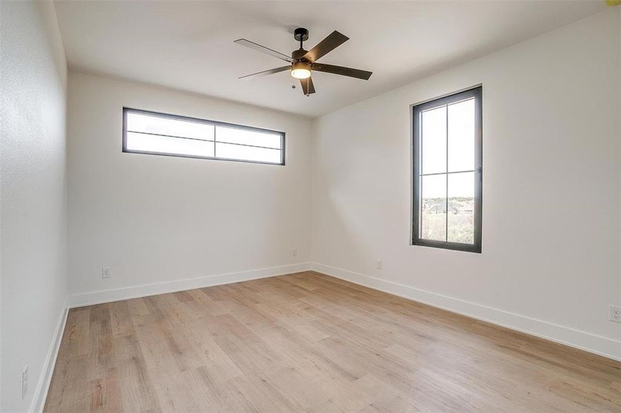 Unfurnished room featuring baseboards, light wood finished floors, and ceiling fan