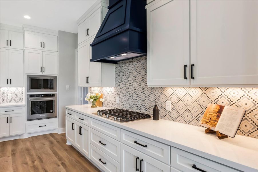 Five-burner cooktop with vent hood. Five-burner cooktop with vent hood.